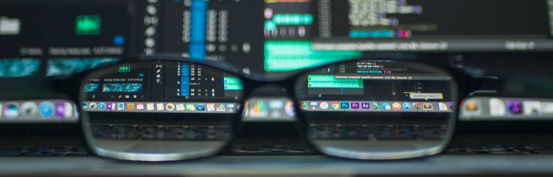 Eyeglasses reflecting computer code on a monitor, ideal for technology and programming themes.