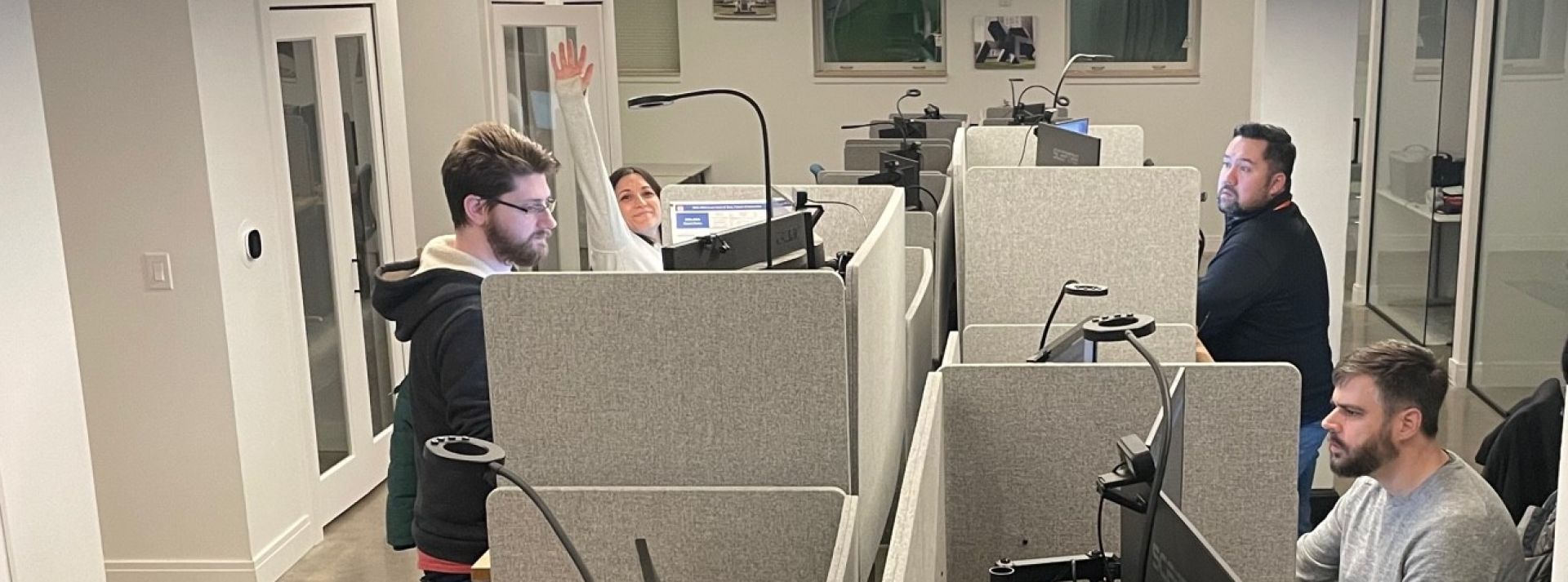 A team collaborates around a laptop for project discussion in a modern office.